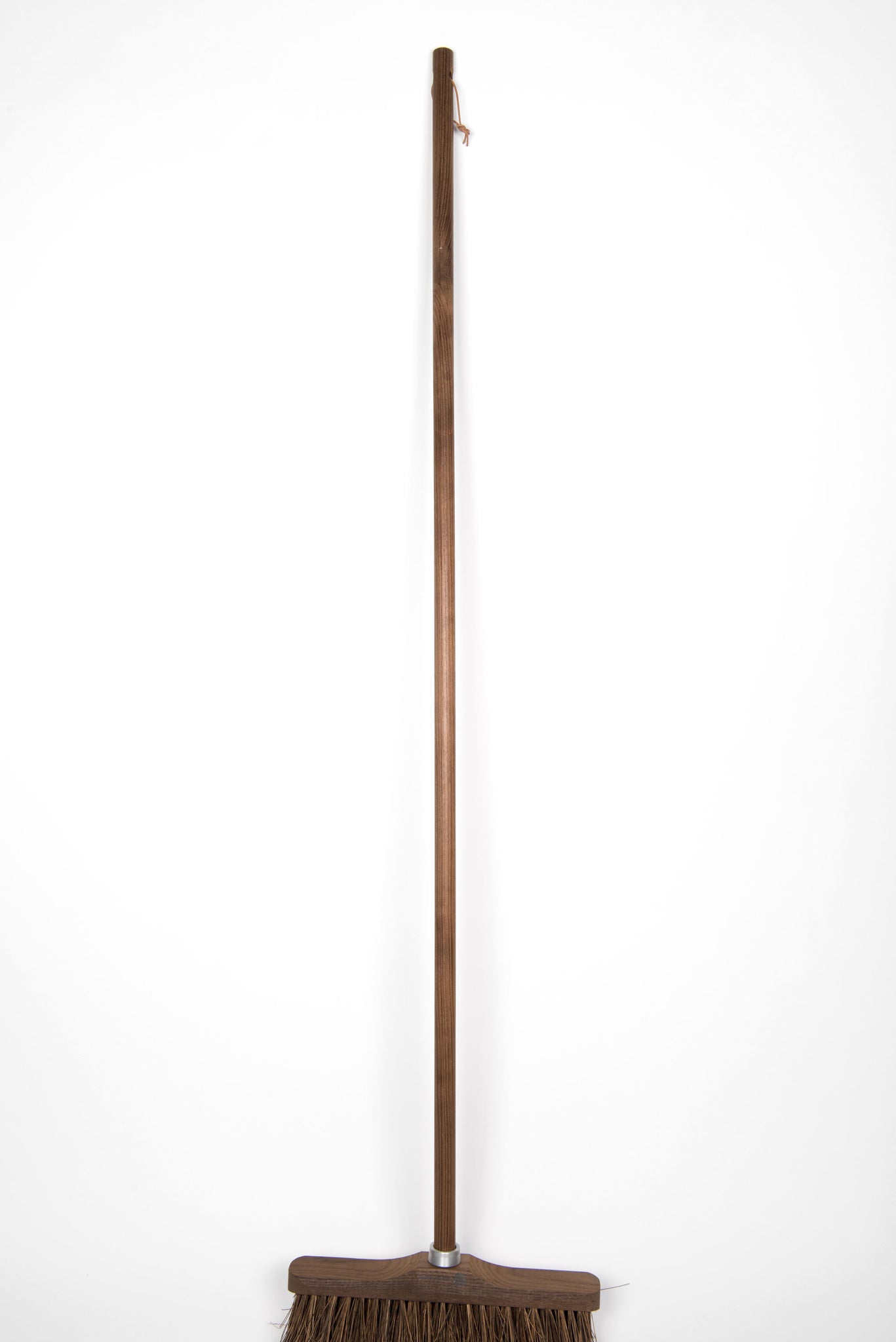 Dark wood broom with natural bristles and leather loop for hanging.