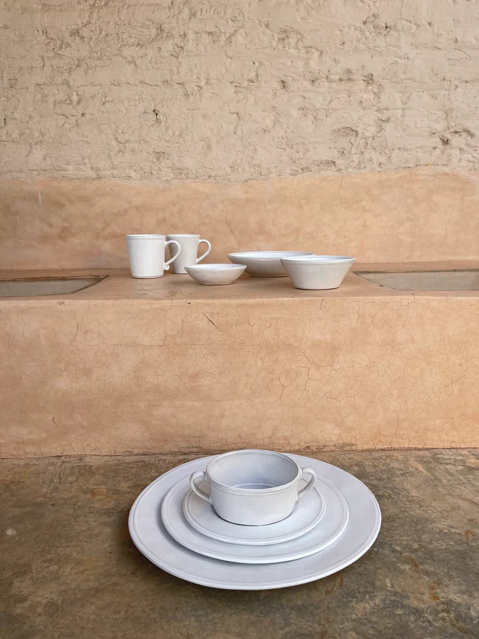 White ceramic mugs, bowls, and plates.