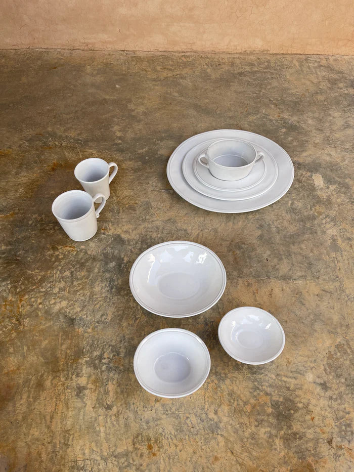 White ceramic mugs, bowls and plates.