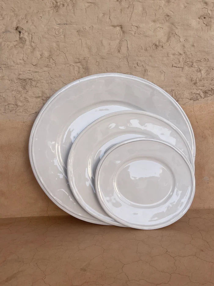 Three white ceramic plates of varying sizes.