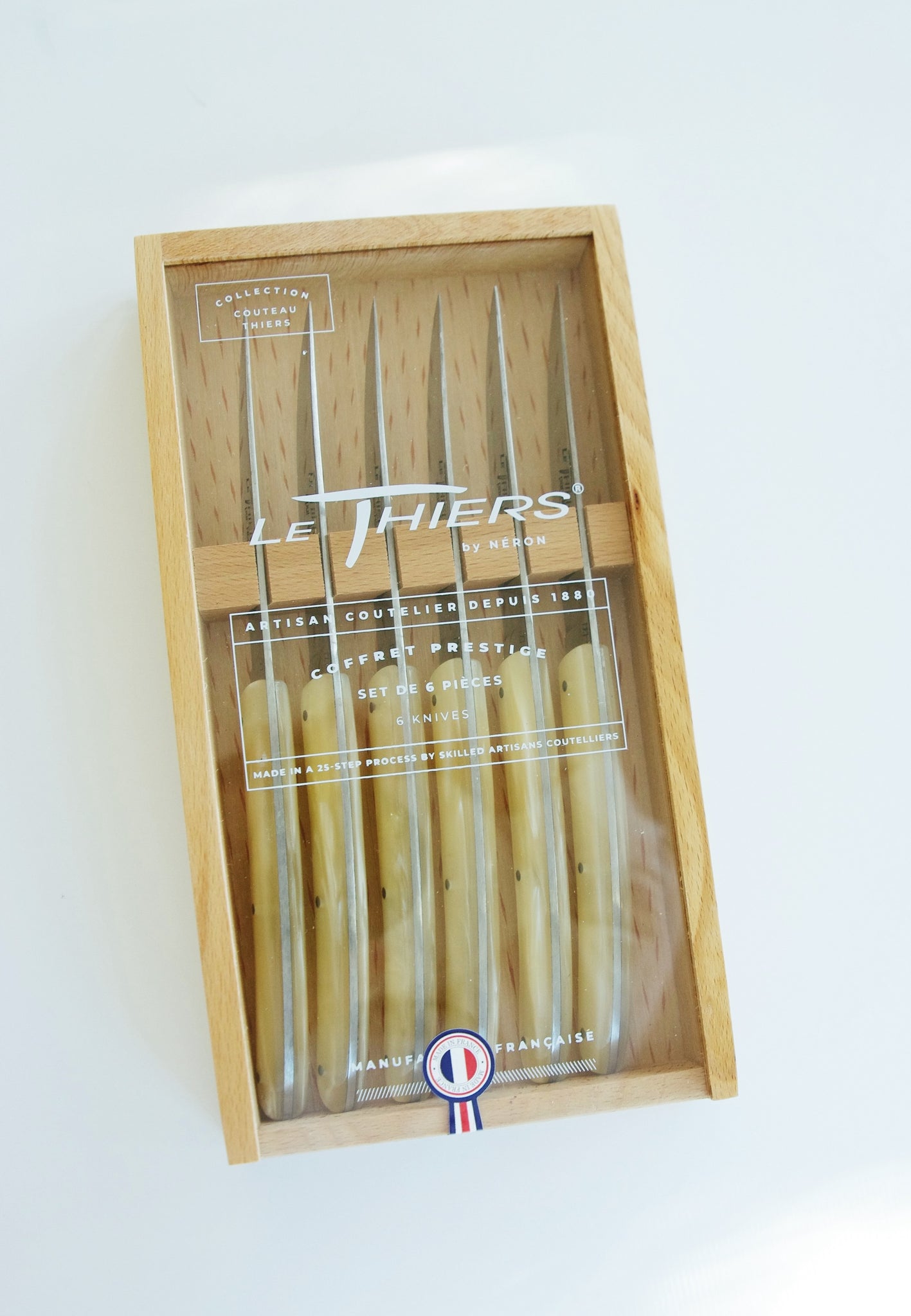 Box of six knives with pearlescent handles. Red white and blue sticker reads Made in France.