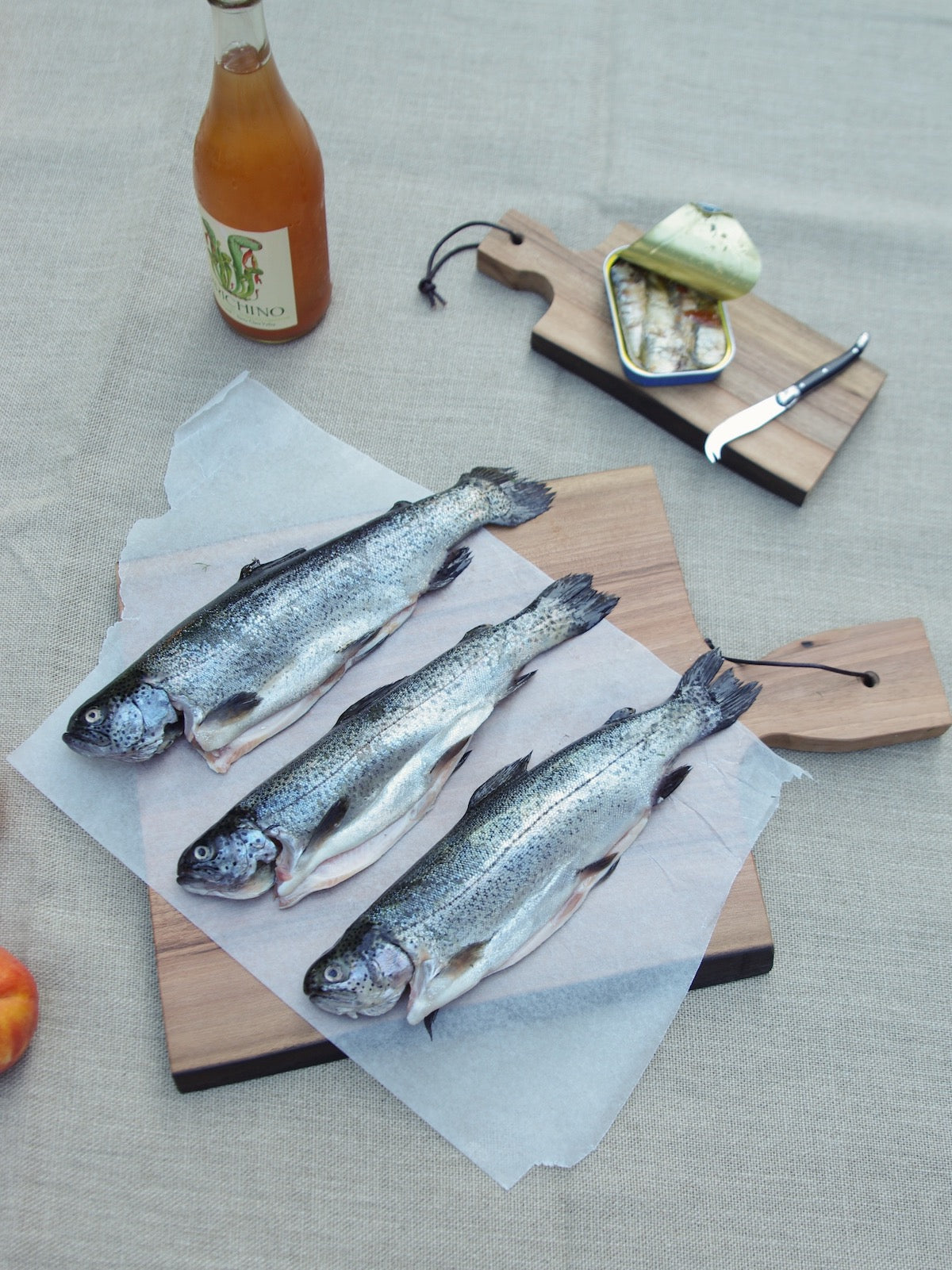 Fish on wooden cutting board. Sardines on smaller wooden cutting board.