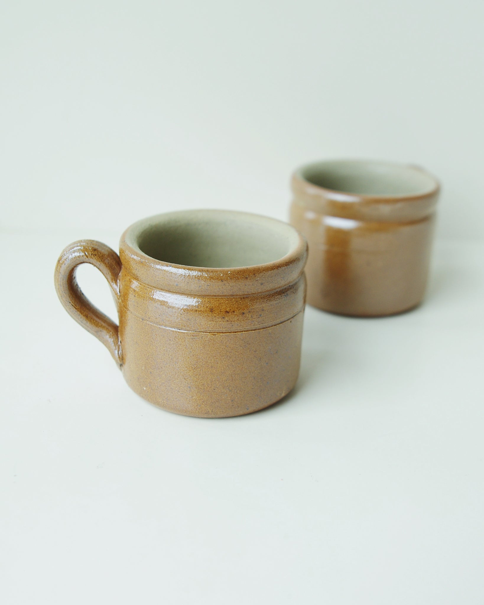 Two brown ceramic mugs.